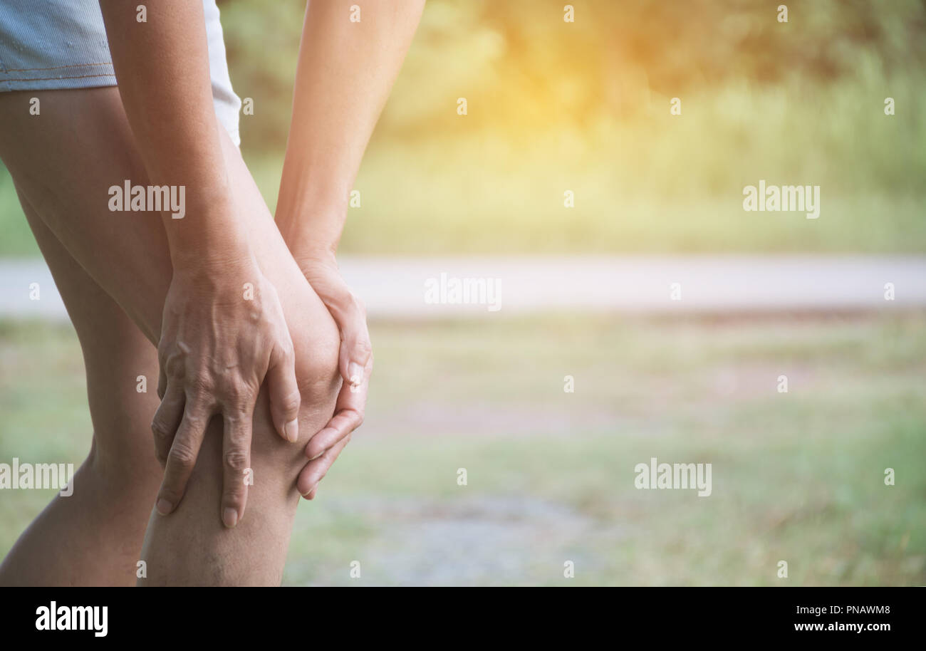The female clings to a bad leg. The pain in her leg. Healthcare and painful concept. Stock Photo