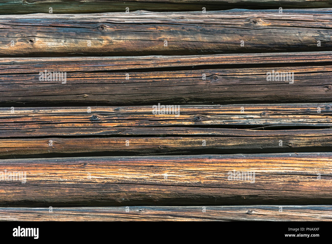 Texture of the walls of the old log house in bright sunlight. Stock Photo