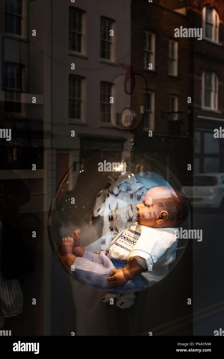 Baby doll in glass bubble,shop window, Knightsbridge,London Stock Photo