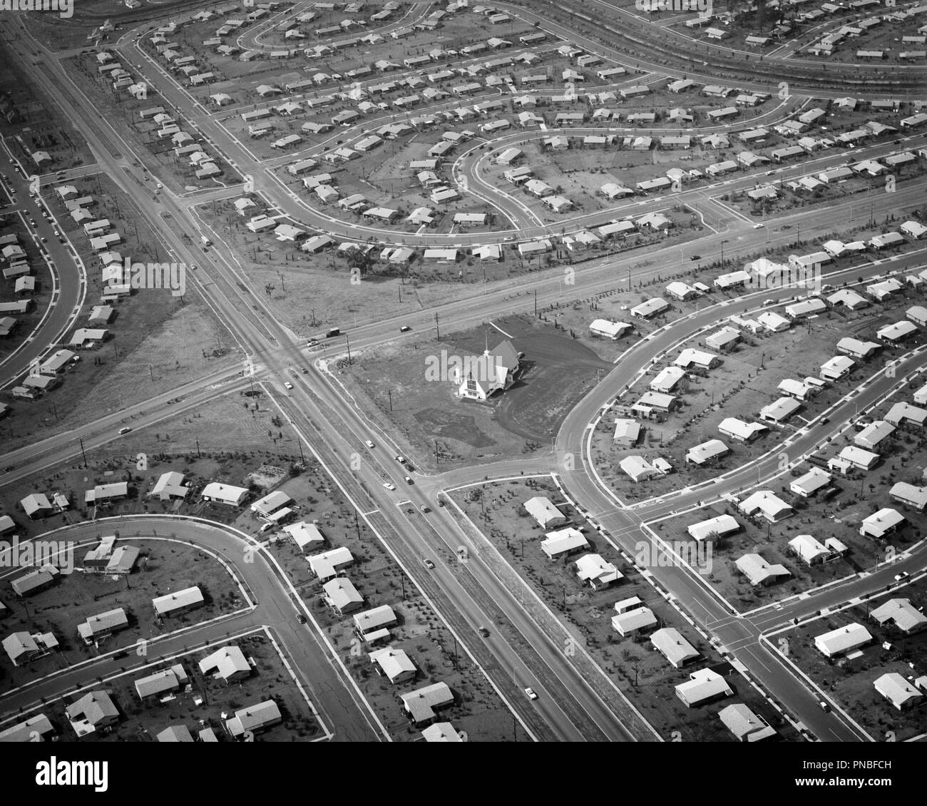 1950s AERIAL OF HOUSING DEVELOPMENT WITH CHURCH BEING BUILT ON CENTRAL INTERSECTION LEVITTOWN PENNSYLVANIA USA - a59 KRU001 HARS OLD FASHIONED Stock Photo