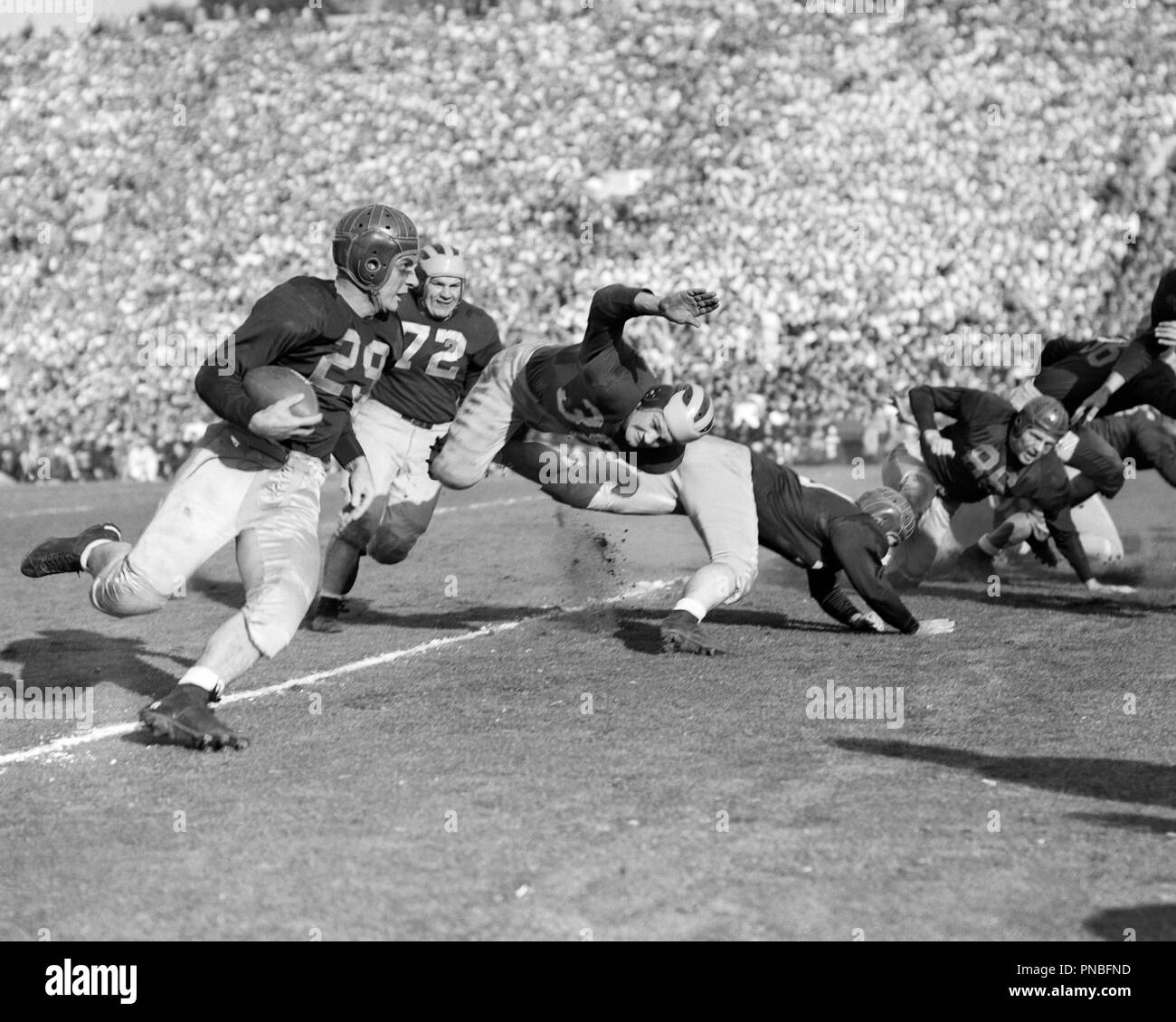 1930s LEATHER HELMET COLLEGE FOOTBALL TEAMS PLAYING MAN RUNNING CARRYING THE BALL - ap008521 CAM001 HARS PLAYERS SPECTATORS B&W GOALS STRATEGY UNIVERSITIES EXCITEMENT CAM001 HIGHER EDUCATION ATHLETES COLLEGES COOPERATION TEAMS TOGETHERNESS YOUNG ADULT MAN AMERICAN FOOTBALL BLACK AND WHITE CAUCASIAN ETHNICITY DATED OLD FASHIONED Stock Photo
