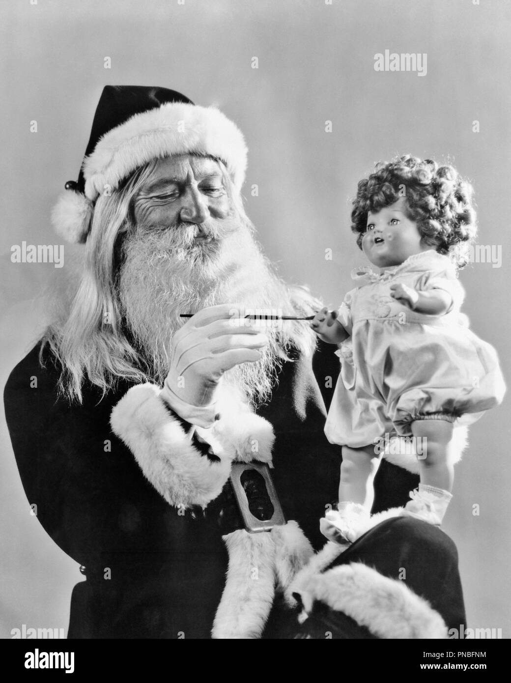 1930s SMILING SANTA CLAUSE PAINTING HAND ON TOY DOLL - ap009782 CAM001 HARS ICON PERSONS MALES SENIOR MAN SAINT SENIOR ADULT B&W ICONS OLDSTERS CHEERFUL OLDSTER SYMBOLISM WHISKER SANTA CLAUS CAM001 SAINT NICHOLAS SAINT NICK OLD SAINT NICK FACIAL HAIR SMILES ELDERS NICK WHITE FUR WHITE-BEARDED BEARDED JOYFUL KRIS KRINGLE KRINGLE KRIS SYMBOLIC WHITE WHISKER WHITE WHISKERS BEARDS NICHOLAS WHISKERS BLACK AND WHITE CAUCASIAN ETHNICITY DATED OLD FASHIONED Stock Photo