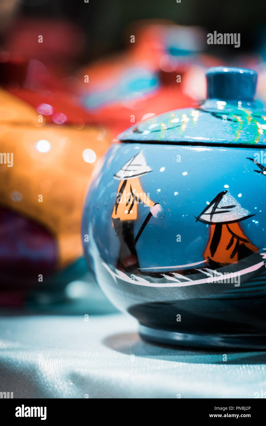 Hong Kong, traditional travel souvenirs. Funerary ash urns, decorated with vivid hand paintings. Shiny, glossy, funeral object. Asiatic culture. Stock Photo