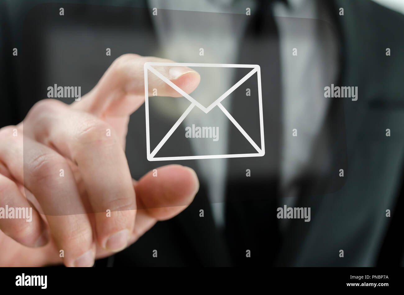 Businessman touching email icon on a virtual screen. Stock Photo