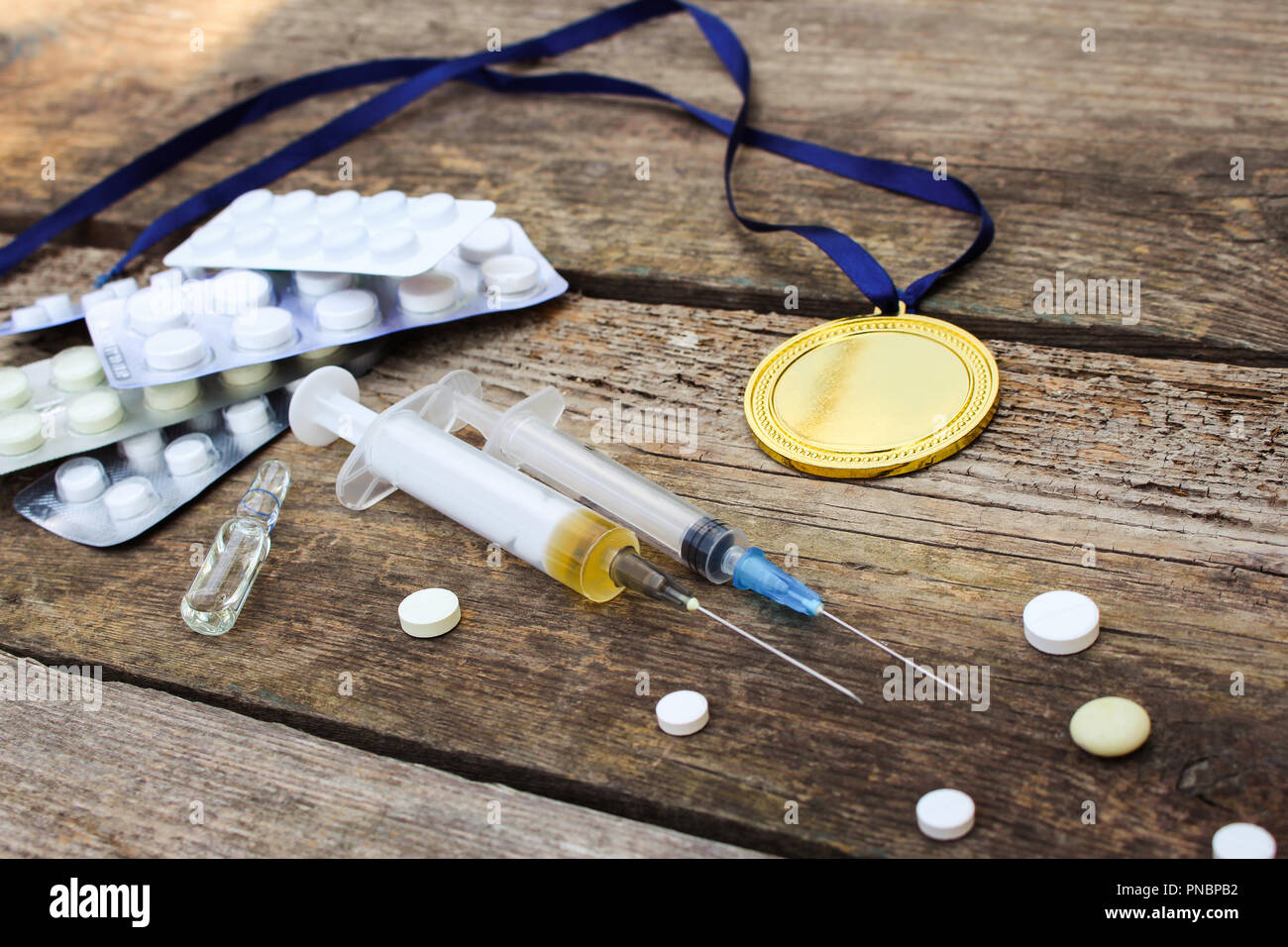 Sports medal and medicines on a wooden background. Toned image. Stock Photo