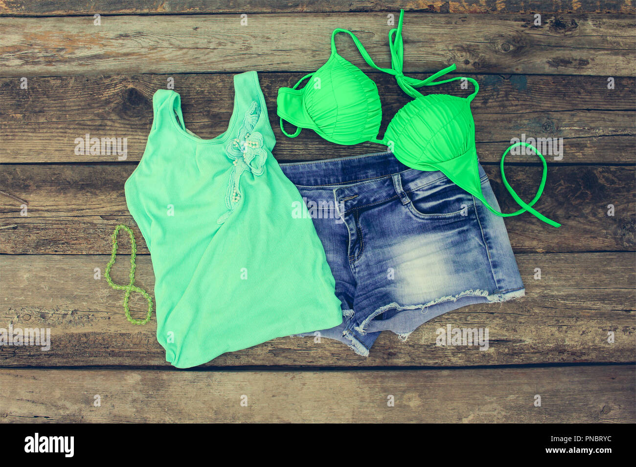 Summer women's clothing: tank top, bathing suit, denim shorts. Toned image  Stock Photo - Alamy