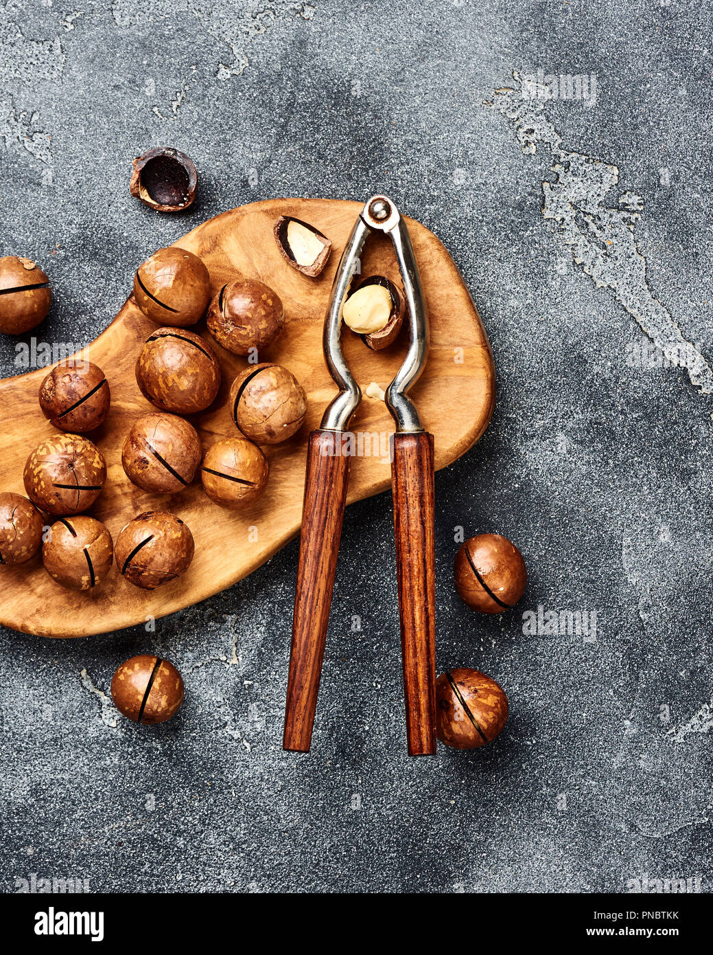Unshelled macadamia nuts on gray background. Top view. Stock Photo