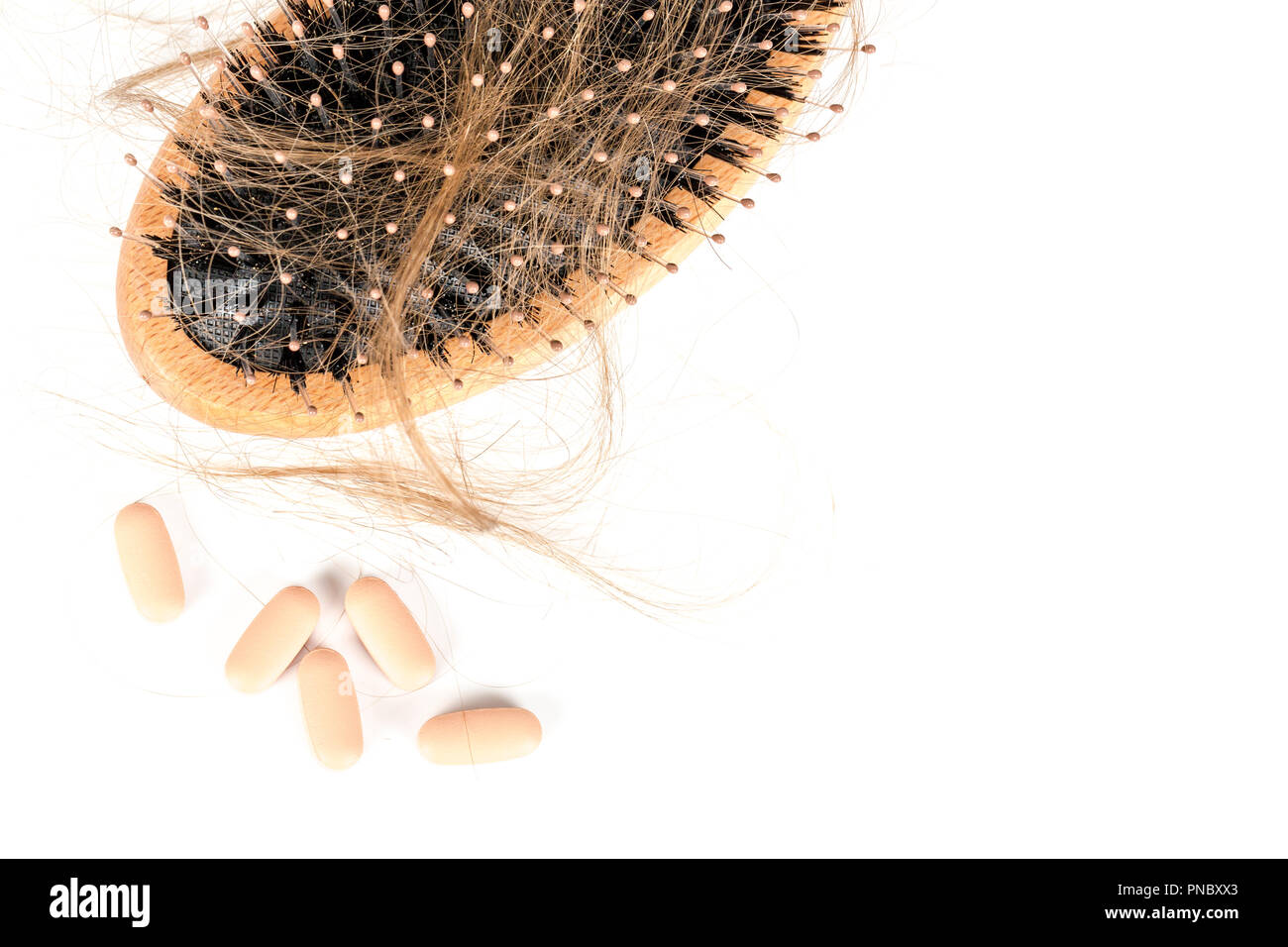 Wood hairbrush on white background. Closeup with long brown hair and