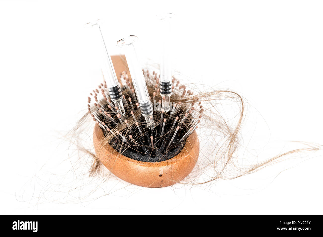 Wood hairbrush on white background. Close-up with long brown hair and ...