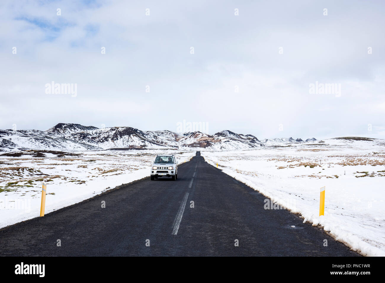 Car motoring on main tarmac road route  from Reykjavik though lava fields in South Iceland with snow depth markers on the roadside. Stock Photo