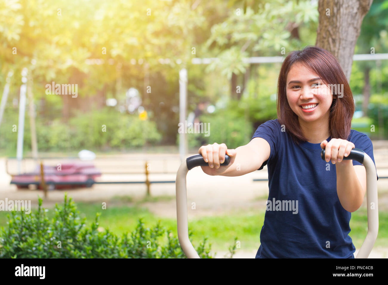 young asian smile enjoy chest exercise in the park for healthy, women workout outdoor. Stock Photo