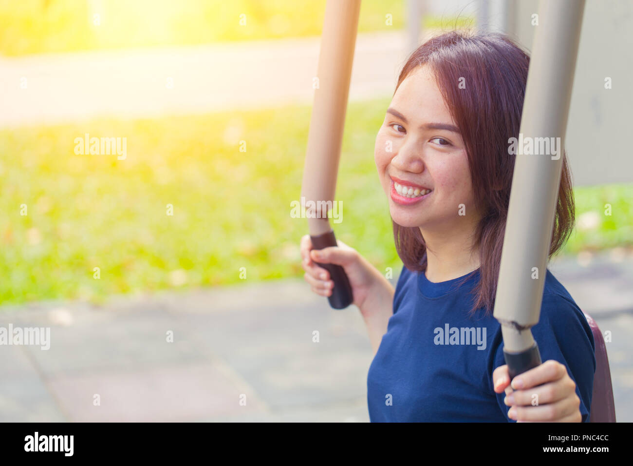 young asian smile enjoy chest exercise in the park for healthy, women workout outdoor. Stock Photo