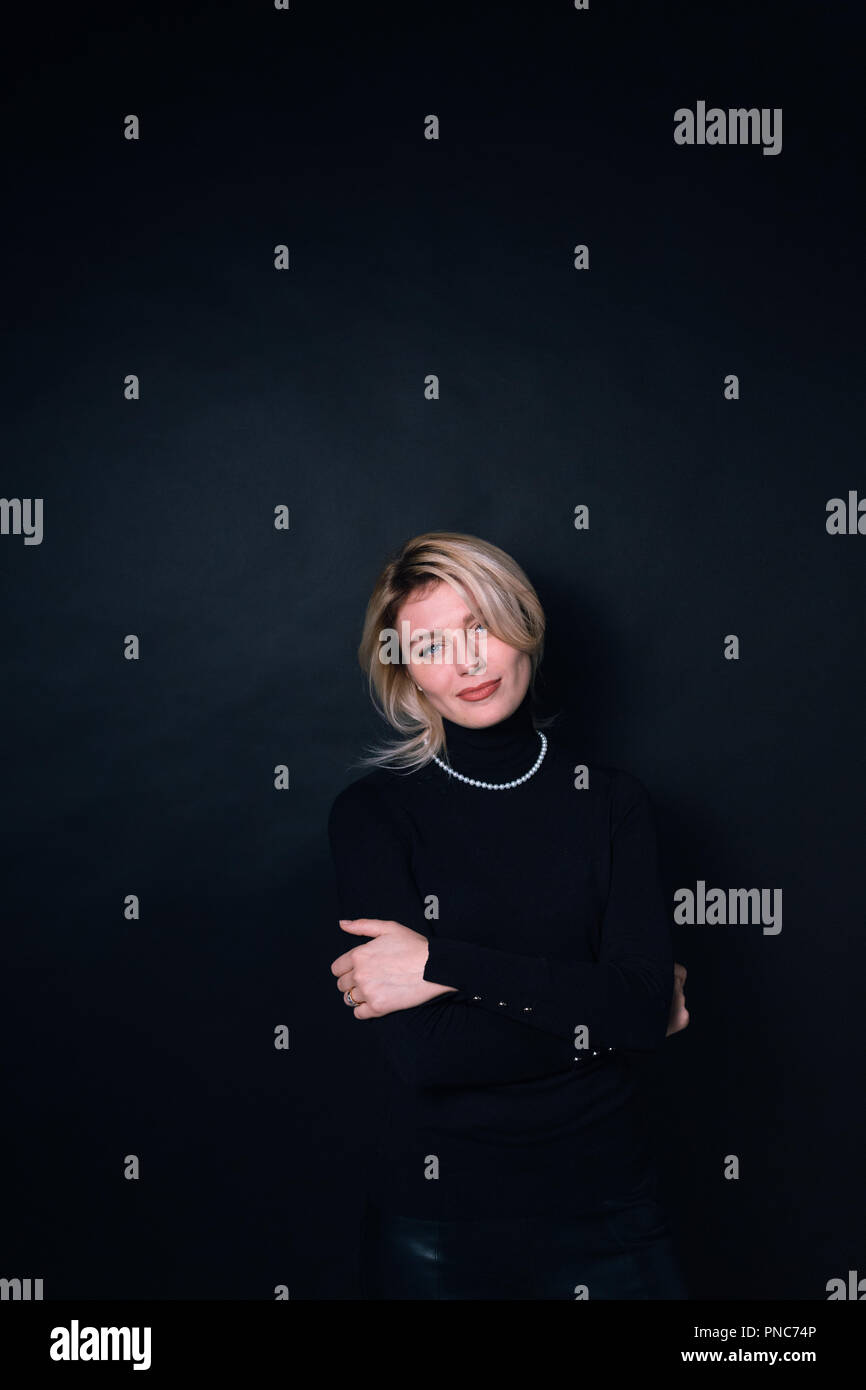 Close up portrait of a young business woman, smiling and looking at the ...