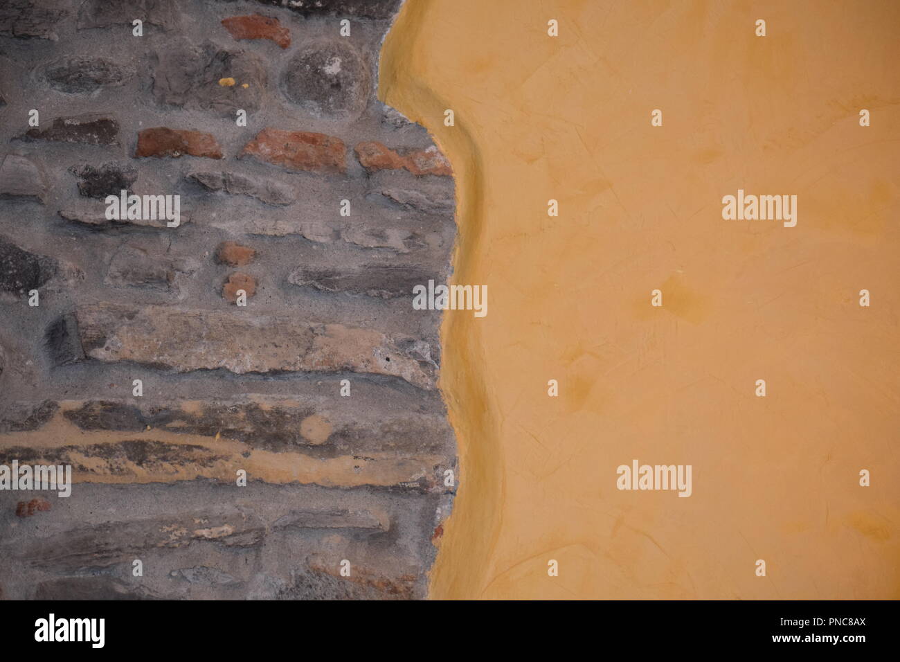 Contrasting Wall Coverings - Open Brick, Yellow paint Stock Photo