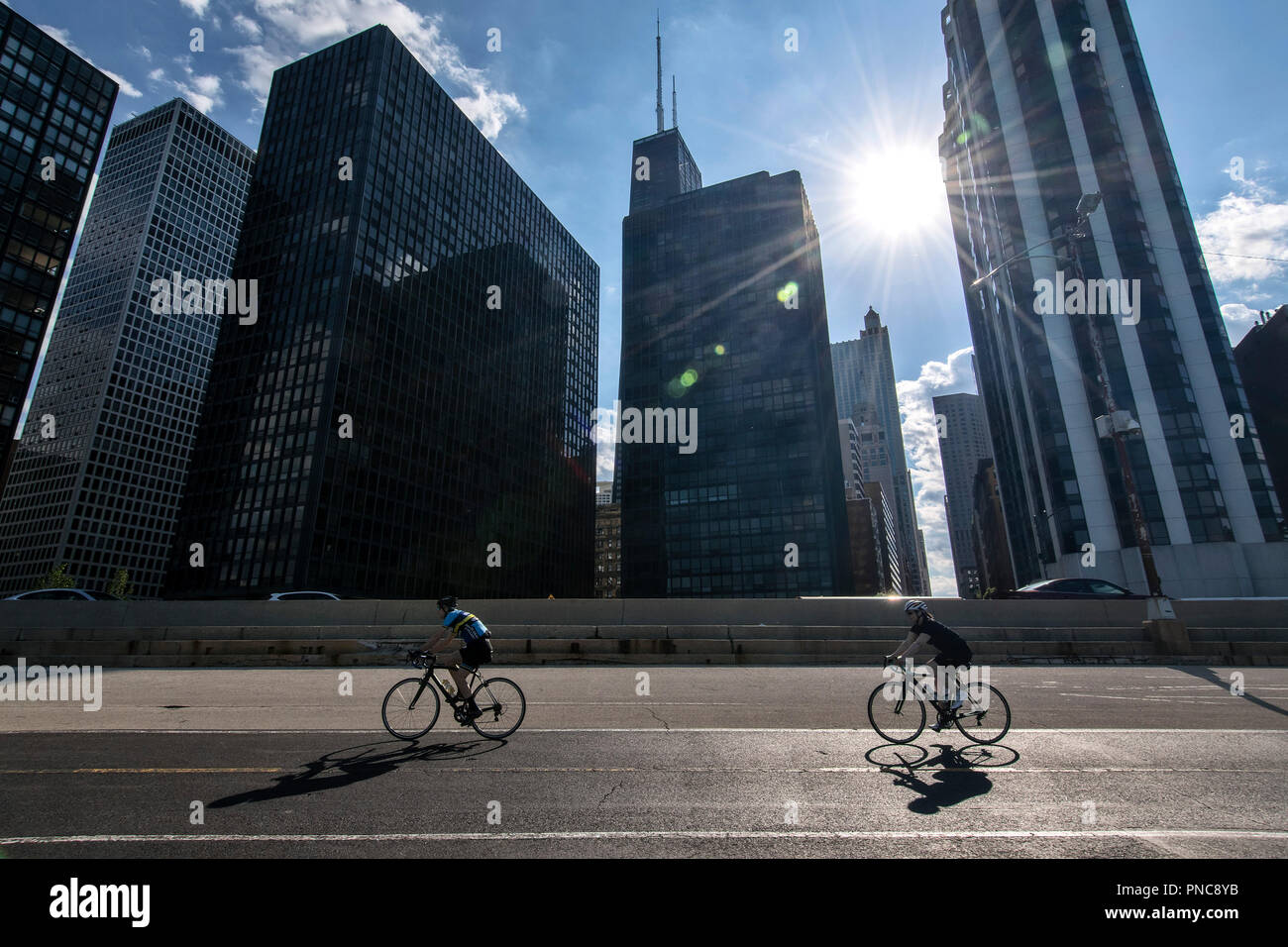 Bicycle riders on Lakefront Trail on Lake Shore Drive with a view of the Chicago, IL skyline. Stock Photo