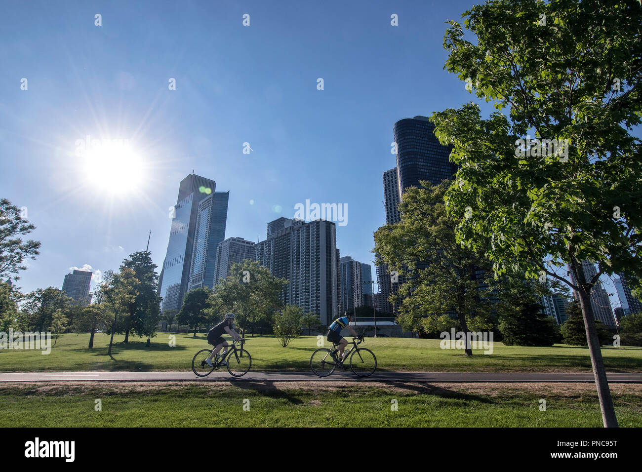 Bicycle riders on Lakefront Trail with the Chicago, IL skyline. Stock Photo