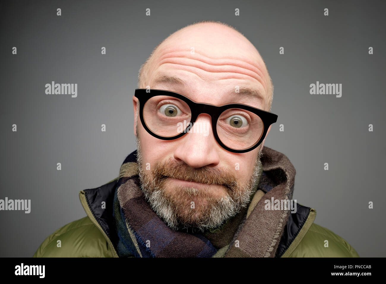 Closeup portrait of european funny bald mature man thinking trying hard to remember something looking confused isolated on gray background. Negative e Stock Photo