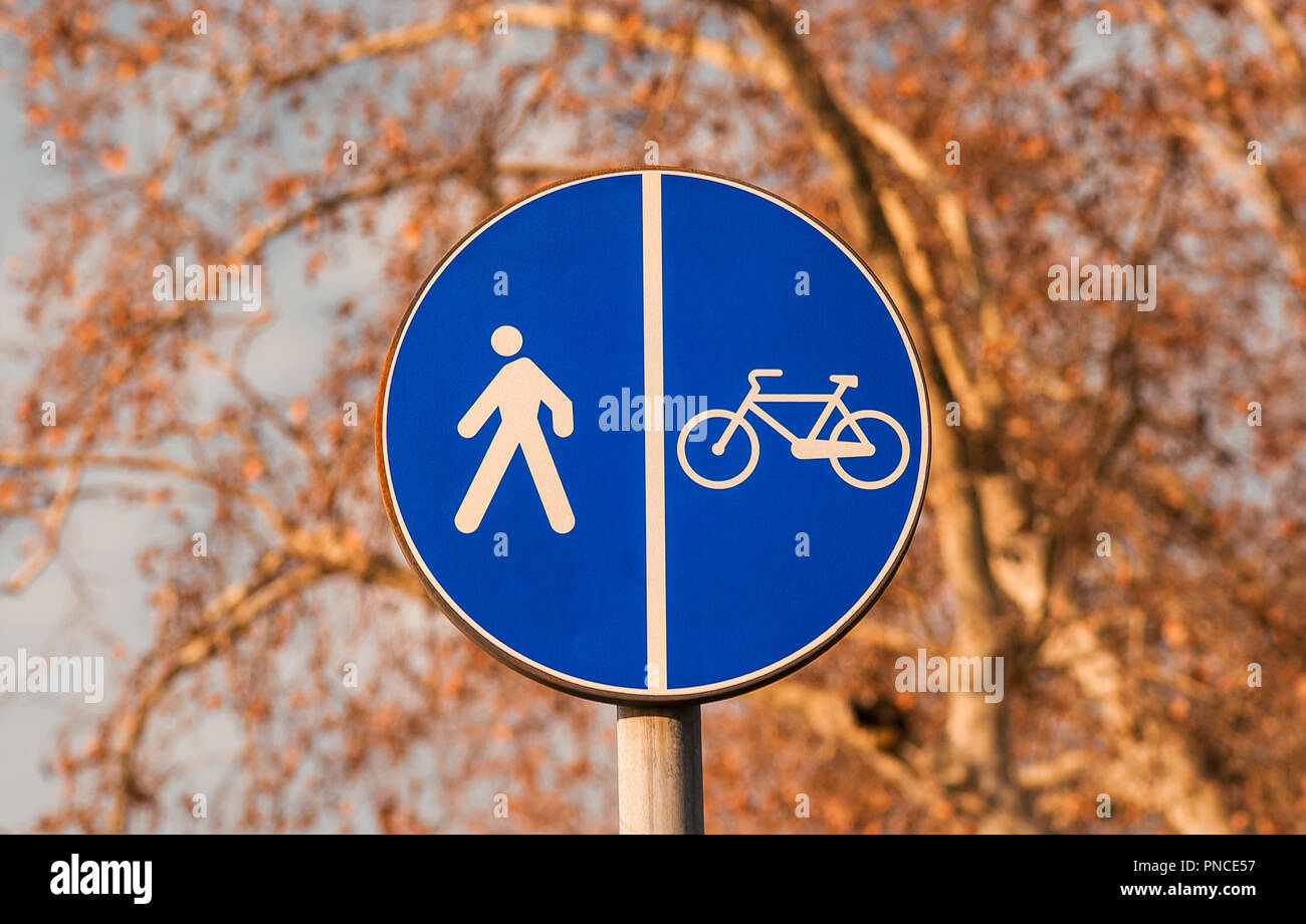 Walking and Cycling in Autumn. Pedestrian and bicycles area road sign against autumn leaves Stock Photo