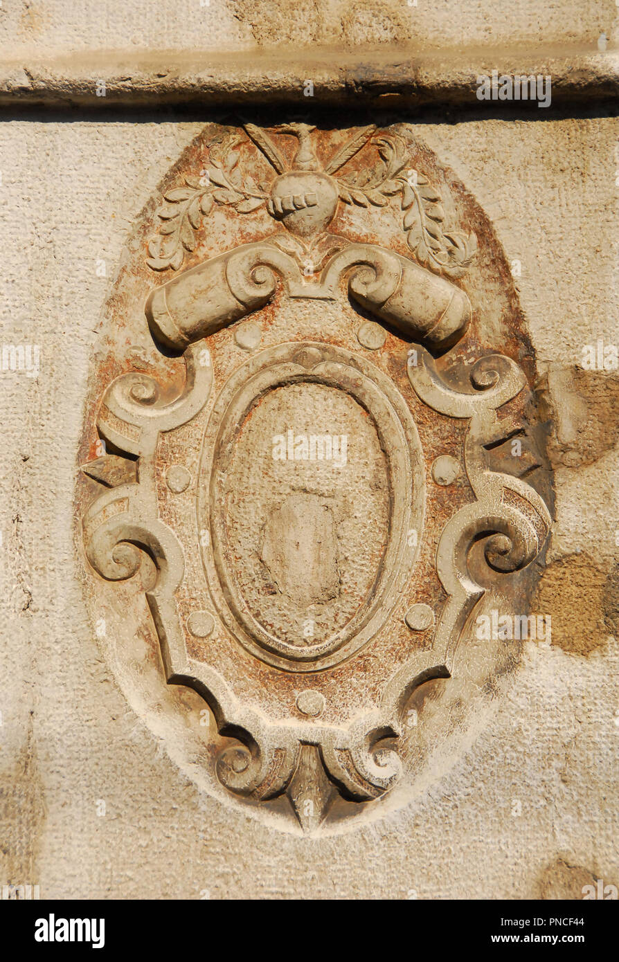 Old heraldic emblem relief with helm and shield on a Venice wall Stock Photo