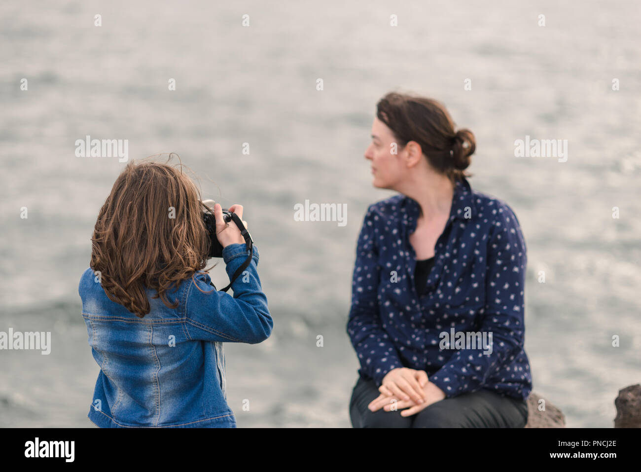 Child photographing a woman, young girl photographing her mother, child photographer Stock Photo