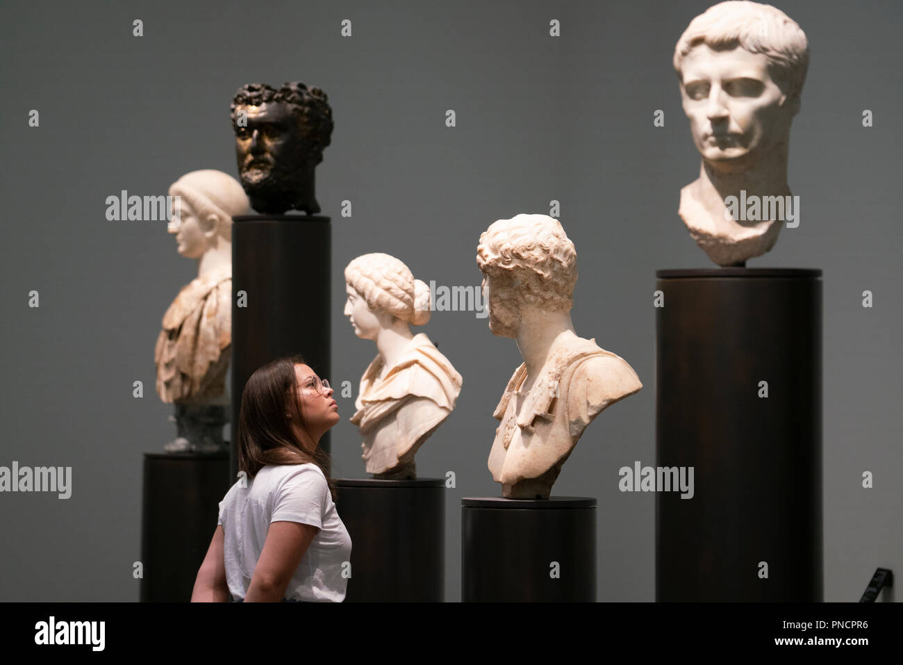 Woman looking at sculptures in Louvre Abu Dhabi at Saadiyat Island Cultural District in Abu Dhabi, UAE. Architect Jean Nouvel Stock Photo