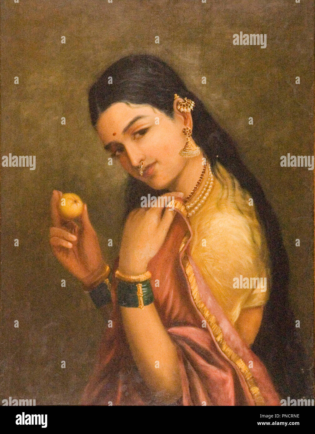 Woman Holding a Fruit. Date/Period: Late 19th century. Painting. Oil on canvas. Height: 600 mm (23.62 in); Width: 450 mm (17.71 in). Author: RAJA RAVI VARMA. Stock Photo
