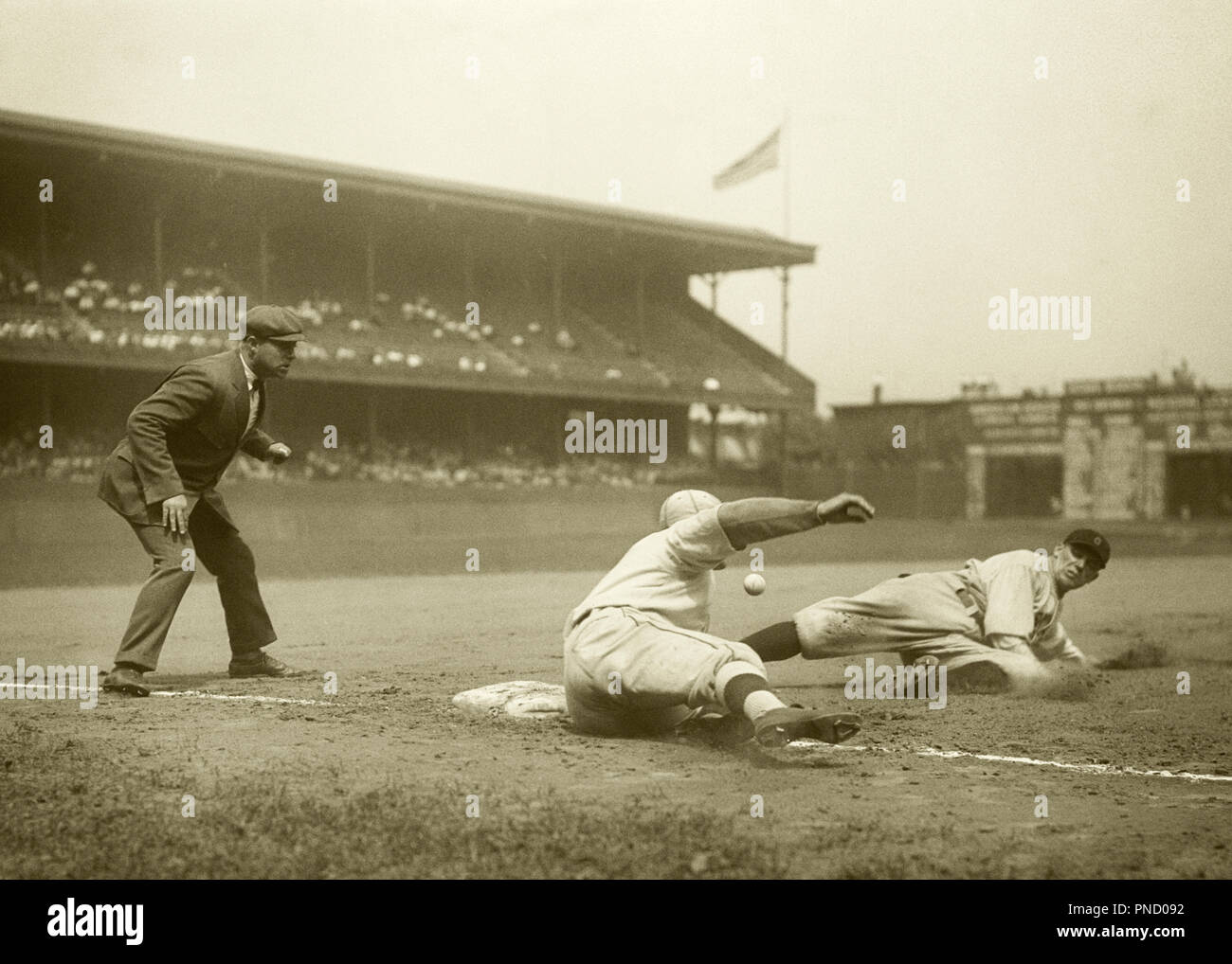 1920s 1926 BASEBALL PLAYER SLIDING SAFE INTO THIRD BASE CLEVELAND INDIANS VS ATHLETICS AT SHIBE PARK PHILADELPHIA PA USA  - b4002 HAR001 HARS MALES ATHLETIC ENTERTAINMENT CONFIDENCE B&W SUCCESS WIDE ANGLE STRENGTH UMPIRE VICTORY STRATEGY BASE EXCITEMENT LOW ANGLE SLIDING 1926 AT INTO AUTHORITY OCCUPATIONS PROFESSIONAL SPORTS AKA GRANDSTANDS VS STYLISH CONNIE MACK STADIUM SHIBE PARK MID-ADULT MID-ADULT MAN PHILADELPHIA ATHLETICS PRECISION YOUNG ADULT MAN BLACK AND WHITE CAUCASIAN ETHNICITY HAR001 OLD FASHIONED Stock Photo