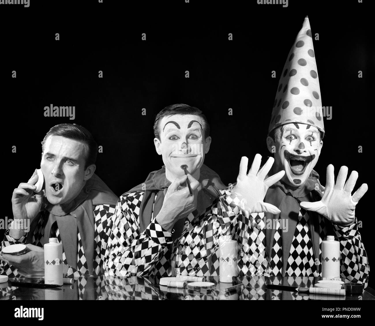 1950s 1960s TRIPTYCH COMPOSITE THREE IMAGES OF MAN CLOWN APPLYING MAKE-UP TO CLEAN FACE BEFORE DURING AFTER  - c3099 DEB001 HARS CELEBRATION JOBS STUDIO SHOT CHANGE COPY SPACE HALF-LENGTH MAKEUP PERSONS MALES ENTERTAINMENT CONFIDENCE EXPRESSIONS B&W CLOWNS EYE CONTACT PERFORMING ARTS SKILL BEFORE OCCUPATION HAPPINESS SKILLS MAKE-UP WEIRD HEAD AND SHOULDERS PERFORMER COMPOSITE TRADITION ZANY UNCONVENTIONAL OF ENTERTAINER OCCUPATIONS POLITICS TRIPLE WHITEFACE CONNECTION COULROPHOBIA CONCEPTUAL MULTIPLE EXPOSURE ACTORS STYLISH VARIATION DEB001 IDIOSYNCRATIC IMAGES AMUSING CREATIVITY ECCENTRIC Stock Photo