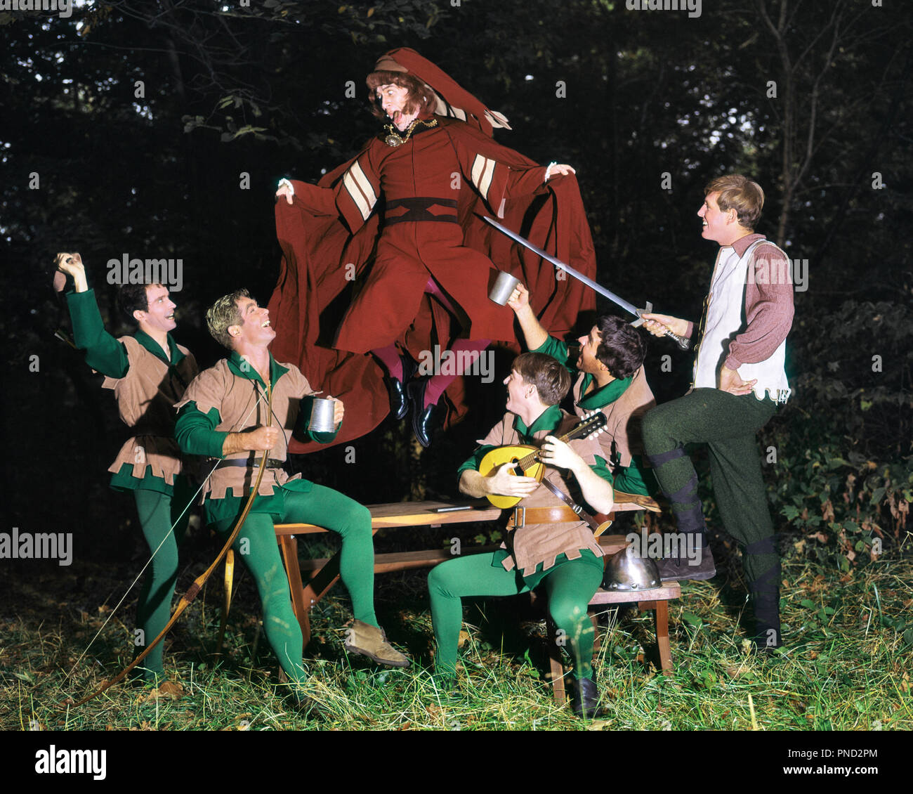 1980s TROUPE OF YOUNG MEN PLAYING ACTING ROBIN HOOD AND HIS MERRY MEN IN SHERWOOD FOREST - kc9929 PHT001 HARS SWORD DRUNK MANY COMMUNICATION SINGER COSTUMES ENTERTAINING LIFESTYLE ACTOR CELEBRATION GROWNUP 6 COMMUNICATING FRIENDSHIP FULL-LENGTH PERSONS GROWN-UP CHARACTER ARROW SIX SING ENTERTAINMENT ACTING VEST GANG PEOPLE STORY HUMOROUS ADVENTURE BEVERAGE PERFORMER ENTERTAIN UNIVERSITIES MERRY EXCITEMENT FAMOUS FLUID RECREATION SONG VOICE VOCAL MUSICAL INSTRUMENT HIGHER EDUCATION DRUNKEN CONCEPTUAL ACTORS NOURISHMENT STYLISH COLLEGES MANDOLIN SHERWOOD FOREST COMMUNICATE HERO OUTLAW PERFORMERS Stock Photo