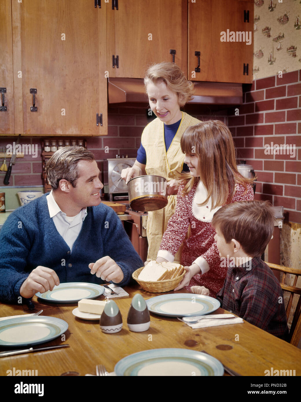 1960s 1970s MOTHER ABOUT TO SERVE FAMILY AT TABLE IN KITCHEN READY TO EAT - kd3124 PHT001 HARS HUSBAND SERVICE INDOOR FOUR DINING EAT INDOORS NOSTALGIC PAIR 4 SUBURBAN COLOR RELATIONSHIP MOTHERS OLD TIME BUSY NOSTALGIA OLD FASHION 1 JUVENILE BALANCE SAFETY TEAMWORK SONS FAMILIES JOY LIFESTYLE PARENTING CELEBRATION FEMALES READY RELATION HUSBANDS GROWNUP HEALTHINESS HOME LIFE HALF-LENGTH DAUGHTERS PERSONS GROWN-UP CARING MALES CONFIDENCE FATHERS HUSBAND AND WIFE MEN AND WOMEN PATERNAL PARENT AND CHILD HUSBANDS AND WIVES HOMEMAKER PARENTS AND CHILDREN FATHERHOOD MATERNAL HAPPINESS HOMEMAKERS Stock Photo