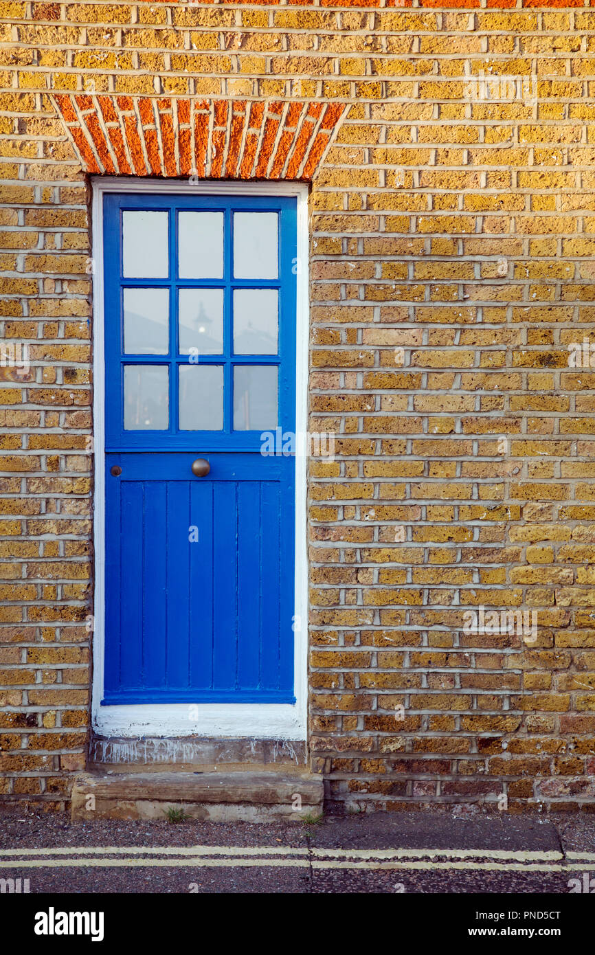 An old blue front door against golden brickwork Stock Photo - Alamy