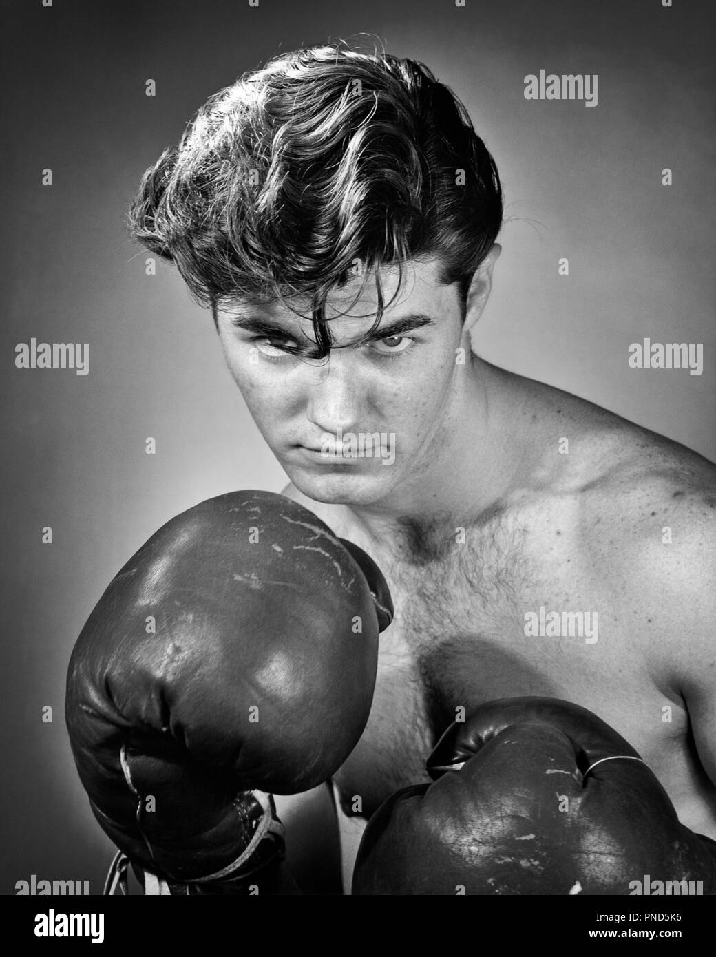 1950s PORTRAIT PRIZE FIGHTER BOXER HAIR FALLING INTO HIS EYES SERIOUS  EXPRESSION LOOKING AT CAMERA - p1830 CLE003 HARS EYE CONTACT MEAN FIGHTER  HEAD AND SHOULDERS STRENGTH COURAGE POISED PRIZE RECREATION INTO