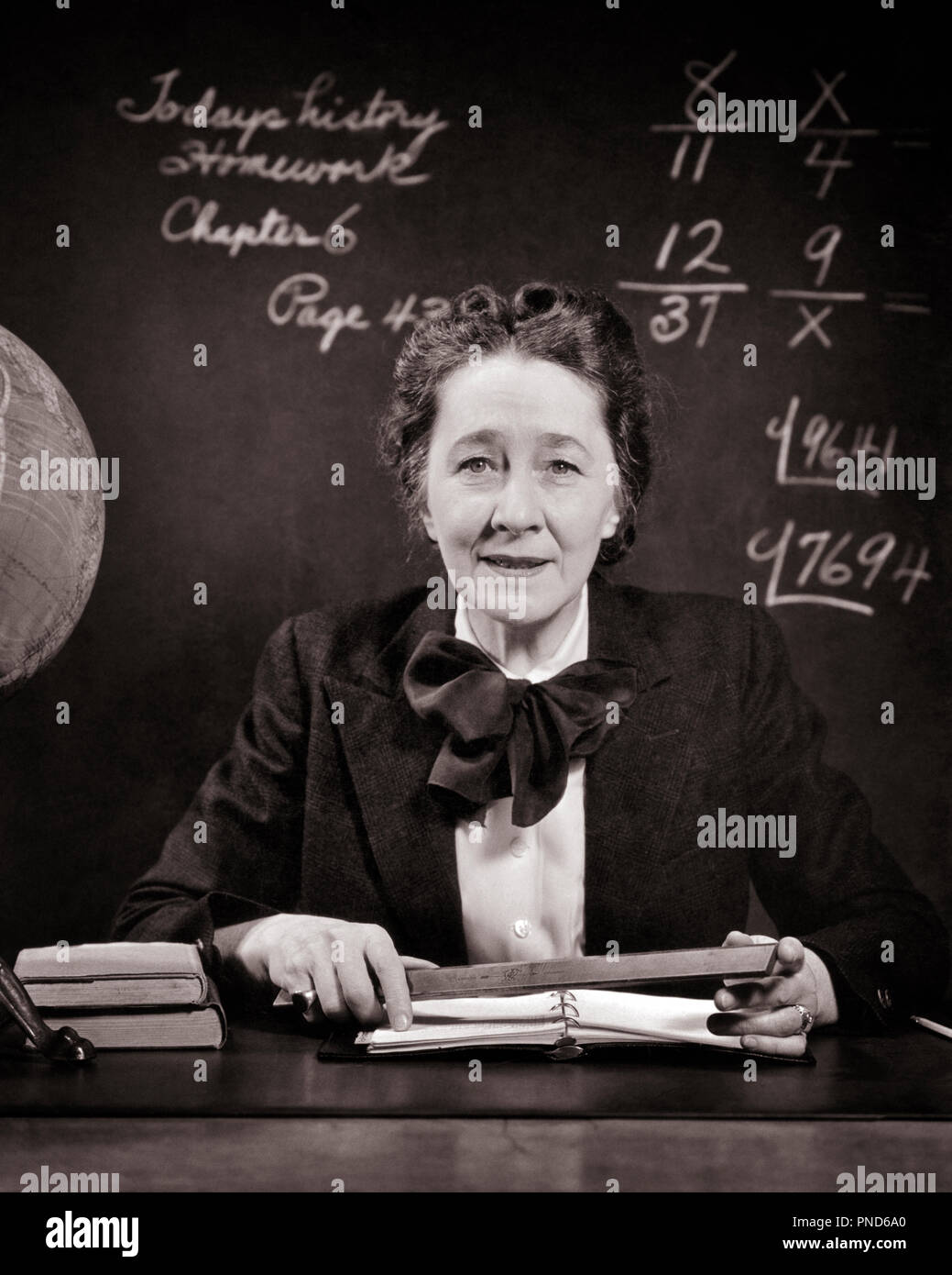 1940s SMILING MIDDLE AGED SCHOOL TEACHER AT DESK BESIDE GLOBE HOLDING RULER LOOKING AT CAMERA MATH ON BLACKBOARD - s11689 HAR001 HARS FEMALES LADIES PERSONS INSPIRATION CARING CONFIDENCE EXPRESSIONS B&W MATHEMATICS EYE CONTACT NICE HEAD AND SHOULDERS CHEERFUL STRENGTH RULER KNOWLEDGE POWERFUL STERN PRIDE AT ON AUTHORITY OCCUPATIONS SMILES STRICT BESIDE JOYFUL OLD MAID PROBLEMS STYLISH MIDDLE AGE PLEASANT MID-ADULT MID-ADULT WOMAN PRECISION PRISSY BLACK AND WHITE CAUCASIAN ETHNICITY HAR001 OLD FASHIONED SEVERE Stock Photo