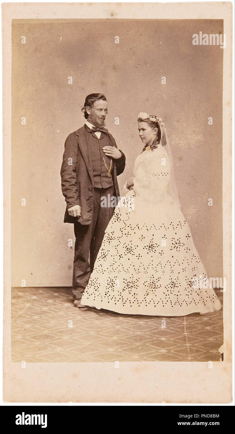 Studio portrait of standing bride and groom. Date/Period: 1864. Photograph. Albumen-silver photograph (carte de visite). Height: 9.10 mm (0.35 in); Width: 5.70 mm (0.22 in). Author: Townsend DURYEA. Stock Photo