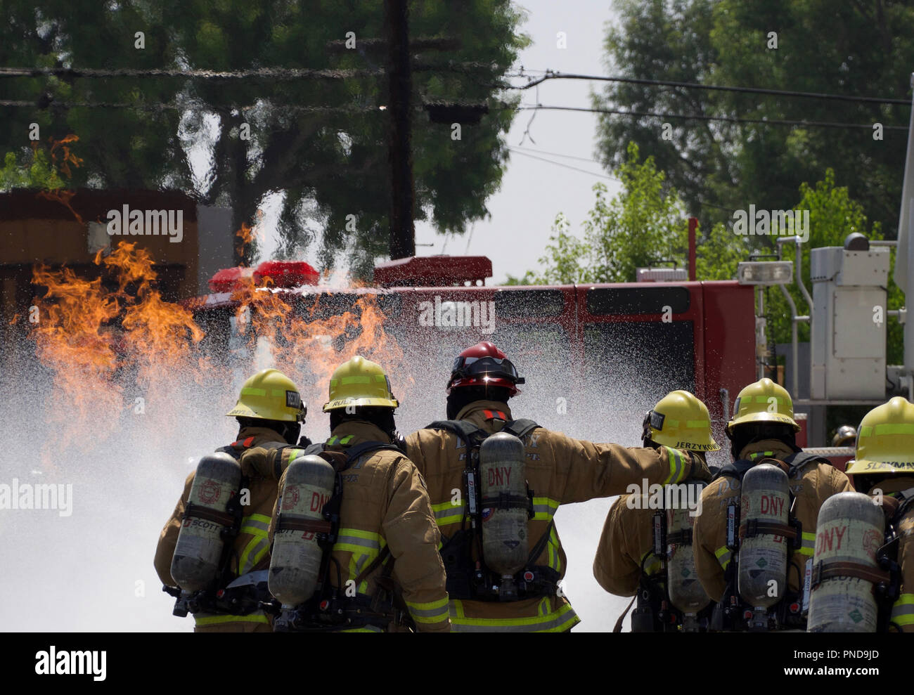 Firemen working together to put out a fire in Downey, CA in 2017 Stock Photo
