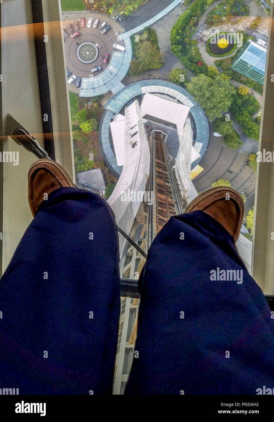 View through the glass floor of the Space Needle's elevator  tower through the feet of someone standing on the glass. Stock Photo