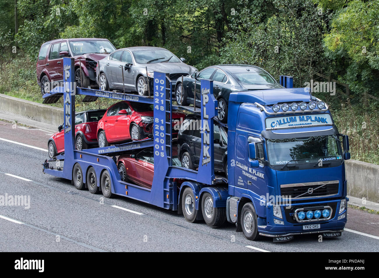 Callum M Plank Transport HGV Heavy goods lorries, trucks & trucking, car logistics transport delivery vehicles on the M6 motorway at Lancaster, UK Stock Photo