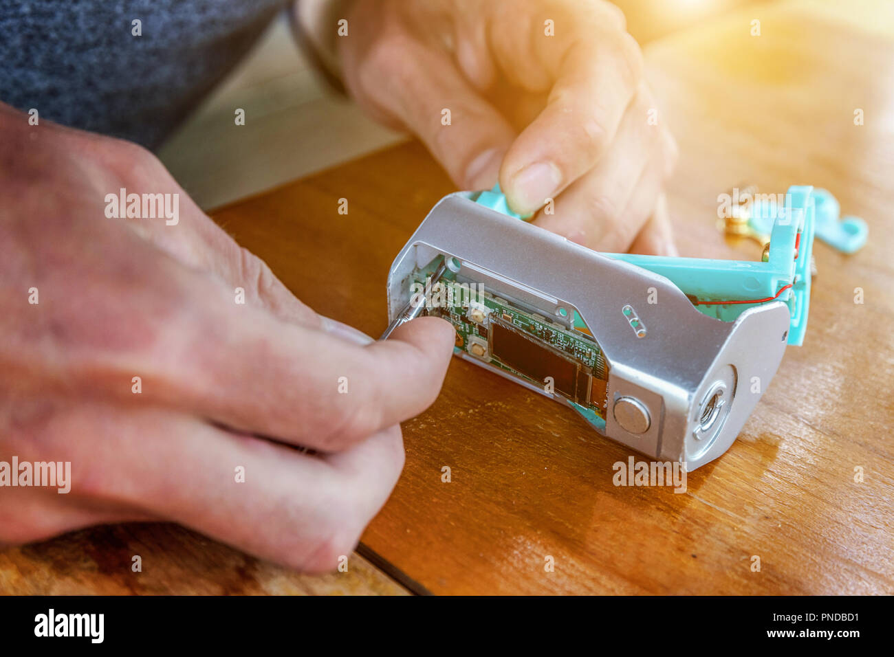 Man hands fixing modern vaporizer e-cig gadget to vape e-liquid. Maintenance of electronic equipment mech mod vaping device. Vaper device repair servi Stock Photo