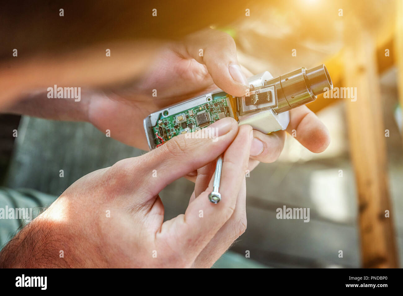 Man hands fixing modern vaporizer e-cig gadget to vape e-liquid. Maintenance of electronic equipment mech mod vaping device. Vaper device repair servi Stock Photo