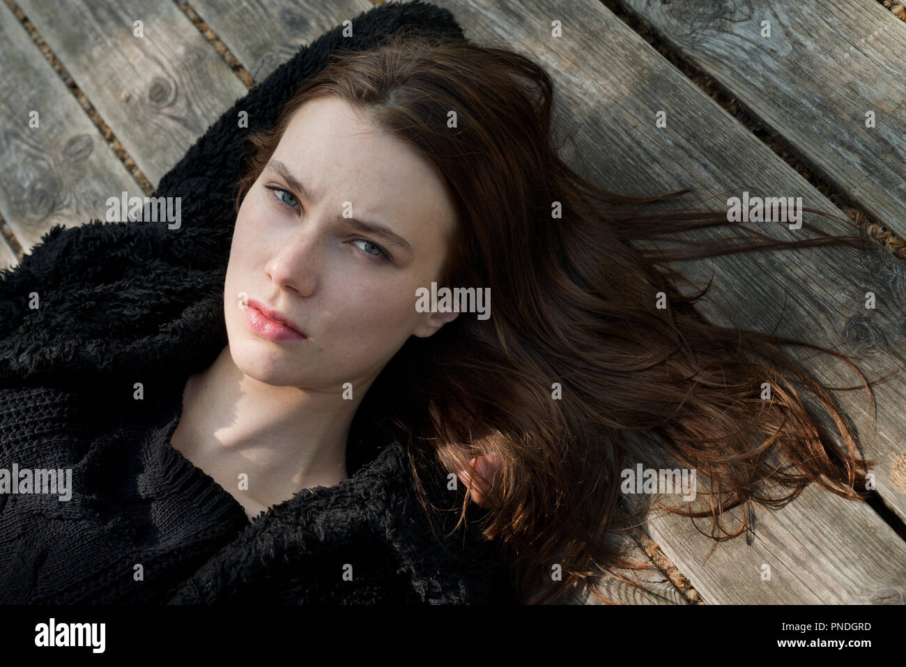 Beautiful young  woman lying on wooden floor Stock Photo