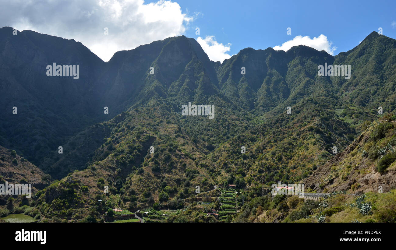Green valley with mountain cliffs in San Sebastian de la Gomera, Canary Islands , Spain Stock Photo