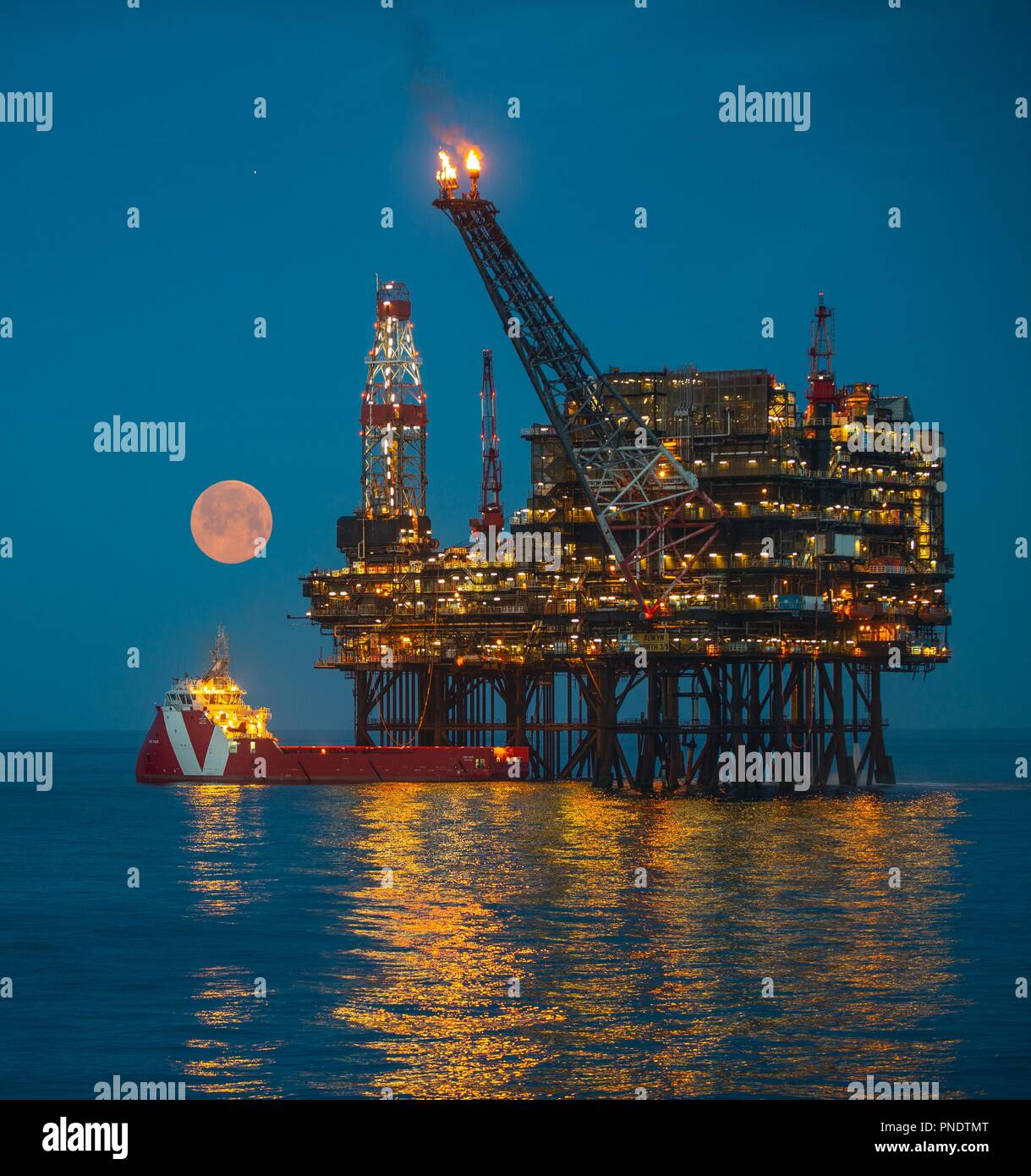 Flare off on North Sea oil platform creating clouds Stock Photo