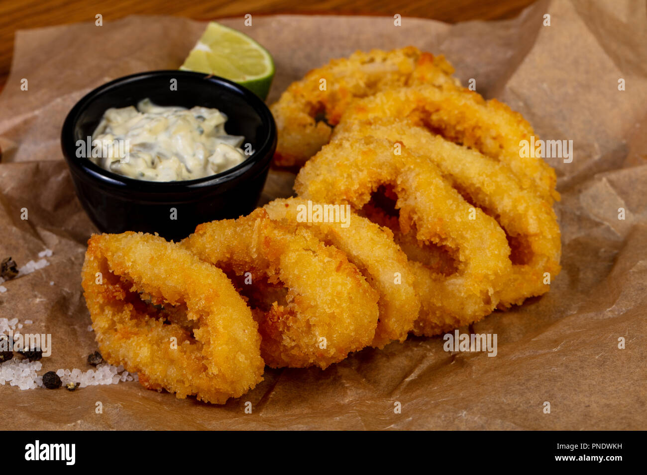 Squid rings tempura with sauce and lime Stock Photo - Alamy