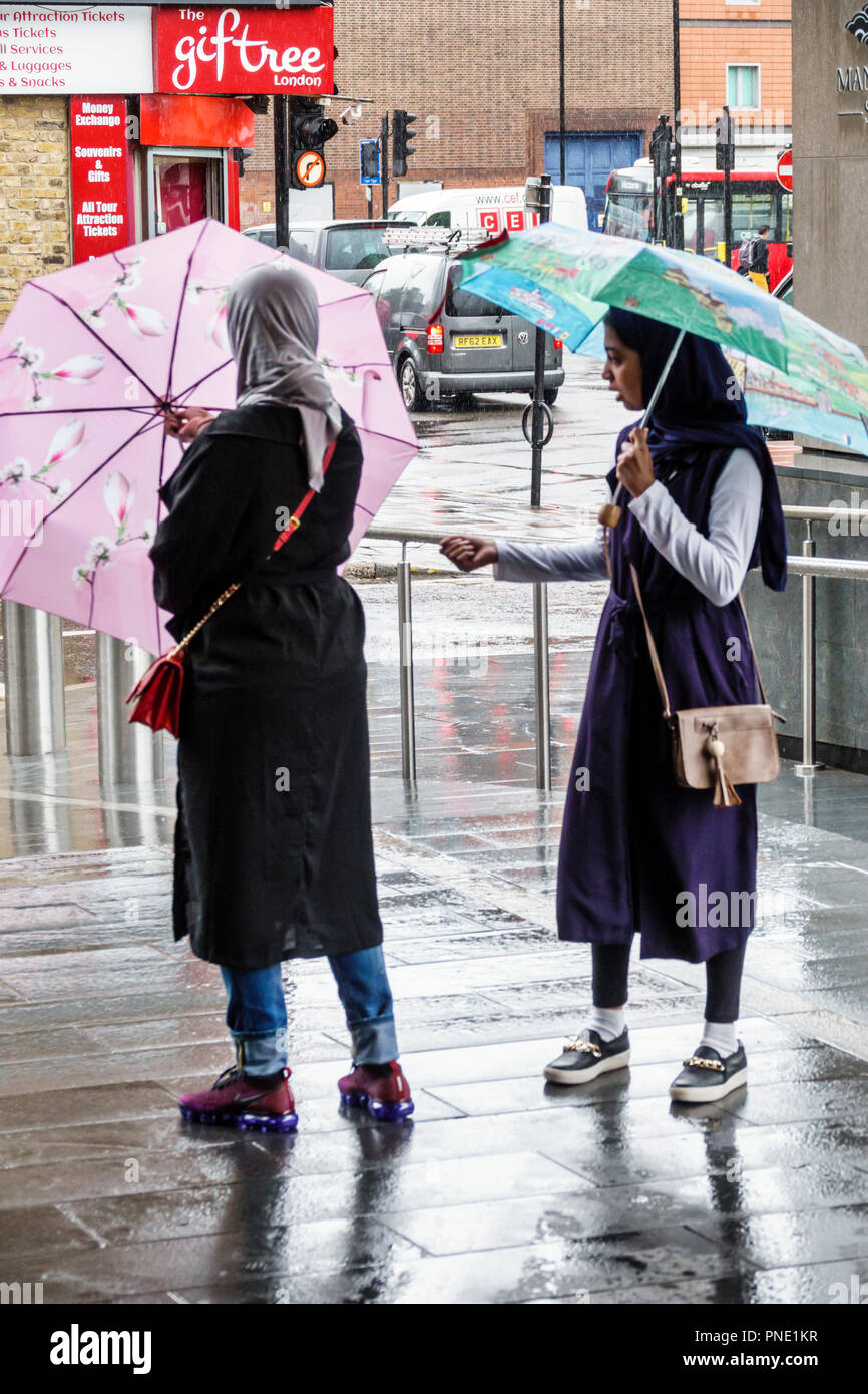London England,UK,United Kingdom Great Britain,South Bank,Lambeth,rain rainy raining day weather,umbrellas,wet pavement,Asian Asians ethnic immigrant Stock Photo