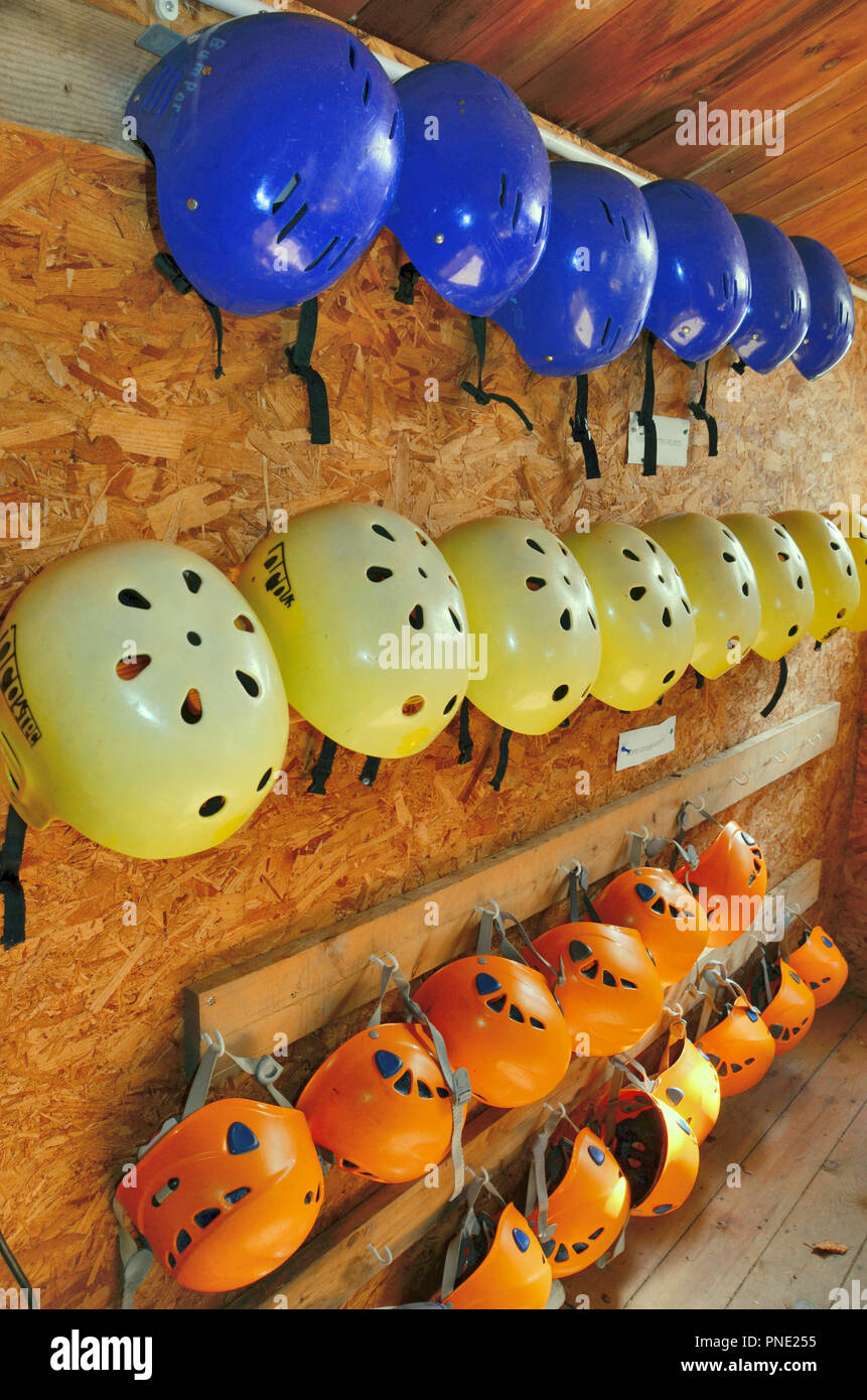 Different types of outdoor activity safety helmets stored in an outdoor centre. Stock Photo