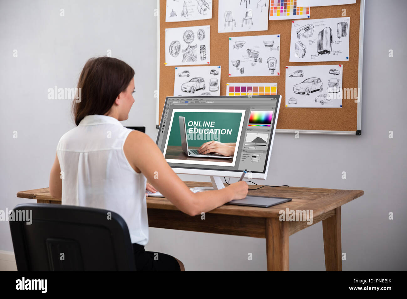 Female Designer Using Graphic Tablet While Working On Computer Stock Photo