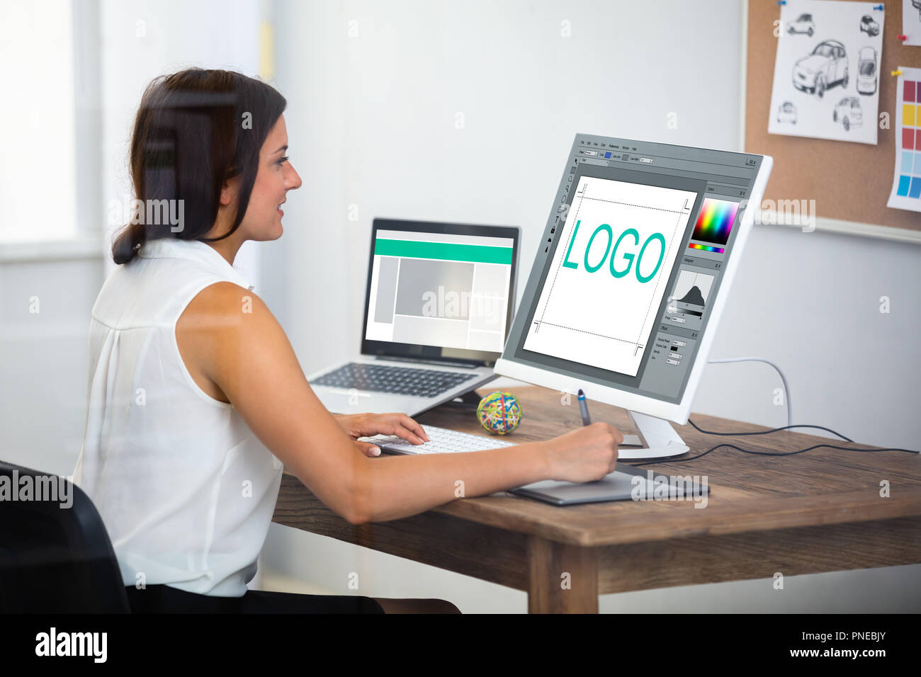 Female Designer Using Graphic Tablet While Working On Computer Stock Photo