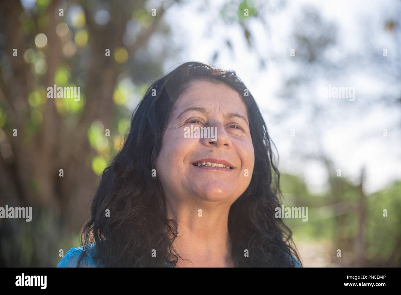 Lovely middle aged woman in the summer park - Laughing mature woman - An women smiling Stock Photo