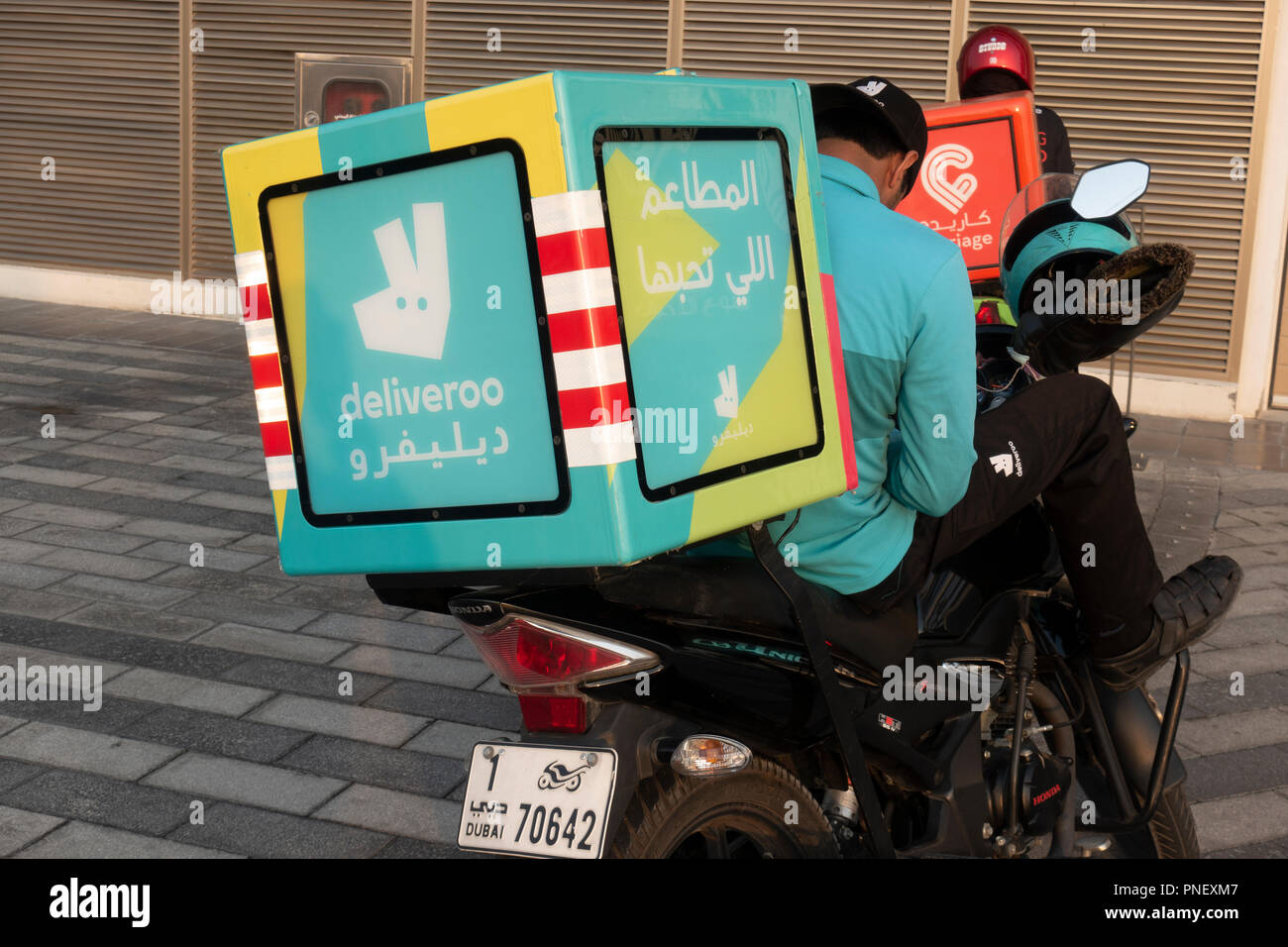 Deliveroo drivers on mopeds in Dubai, UAE Stock Photo