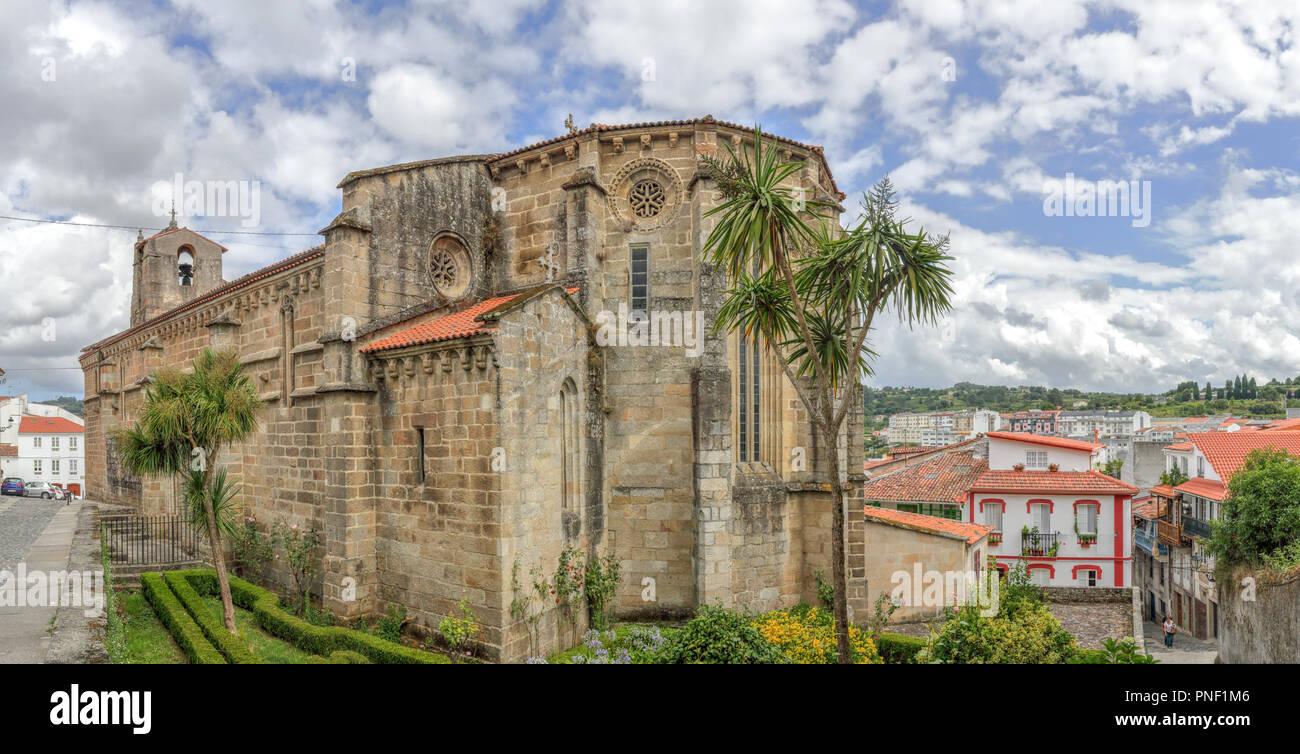 A landscape with the Santa Maria del Azogue church (Iglesia de Santa Maria del Azogue), some palm trees and a blue cloudy sky in Betanzos, Spain Stock Photo